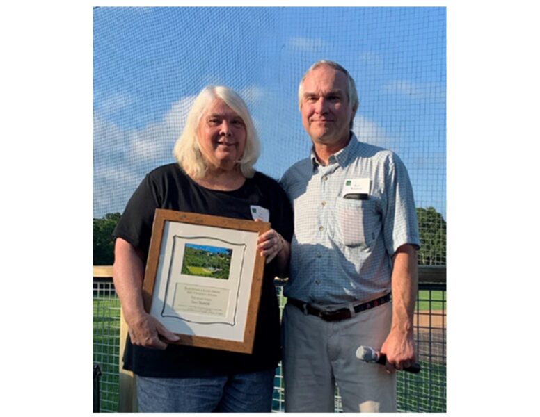 Two people holding framed award plaque