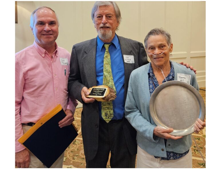 Three people posing with awards